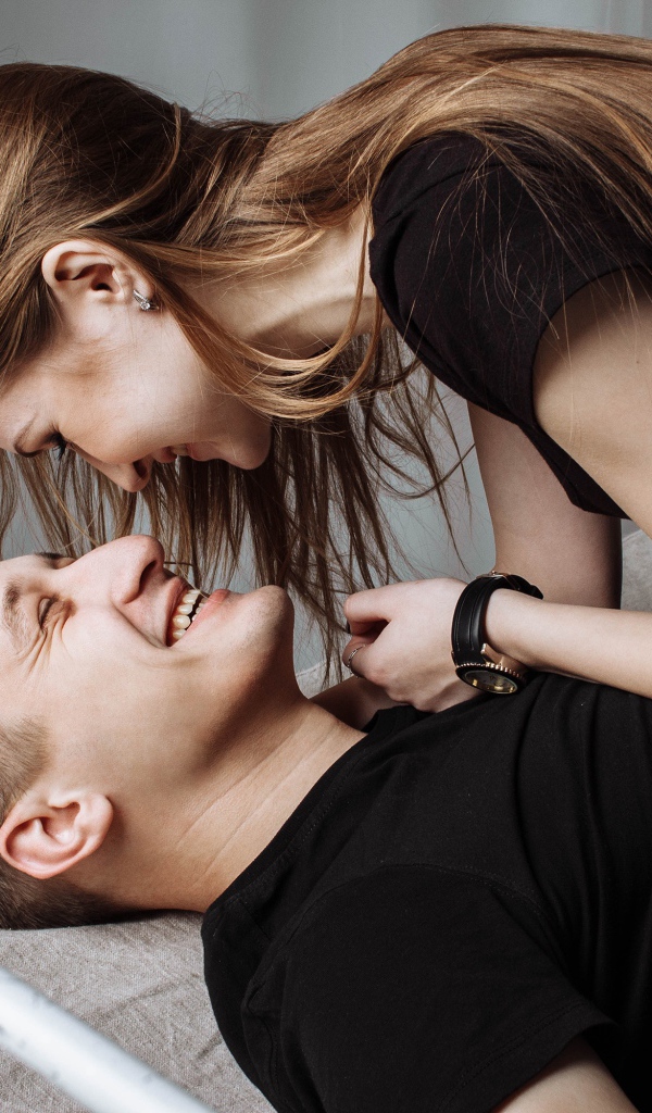 Веселая влюбленная пара парень и девушка на кровати