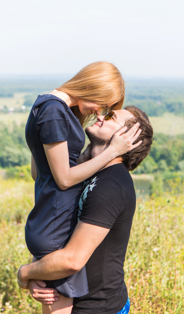 Влюбленная пара обнимается на поле 