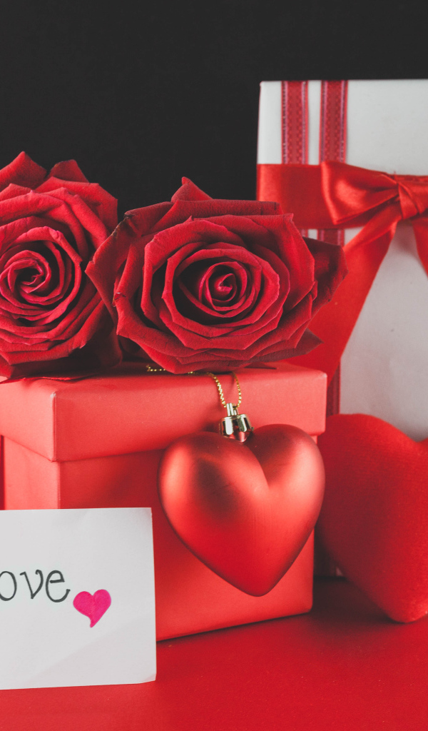 Коробки с подарками на столе с красными розами и сердцем