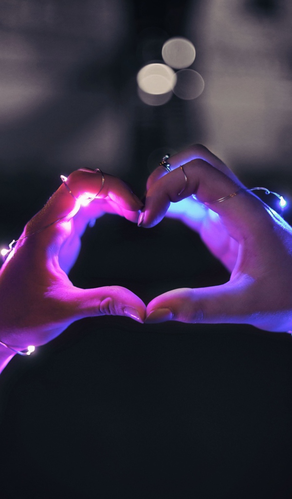 Девушка делает сердце руками