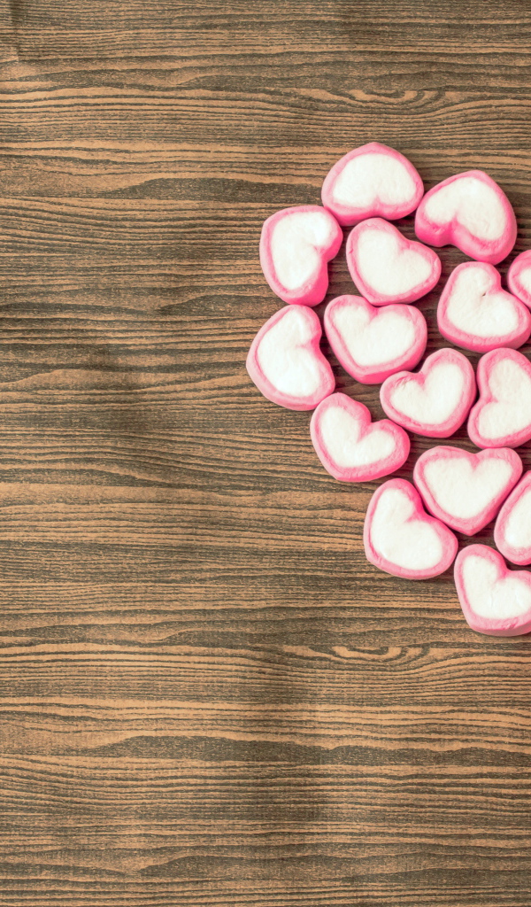 Сердце из конфет на деревянном столе