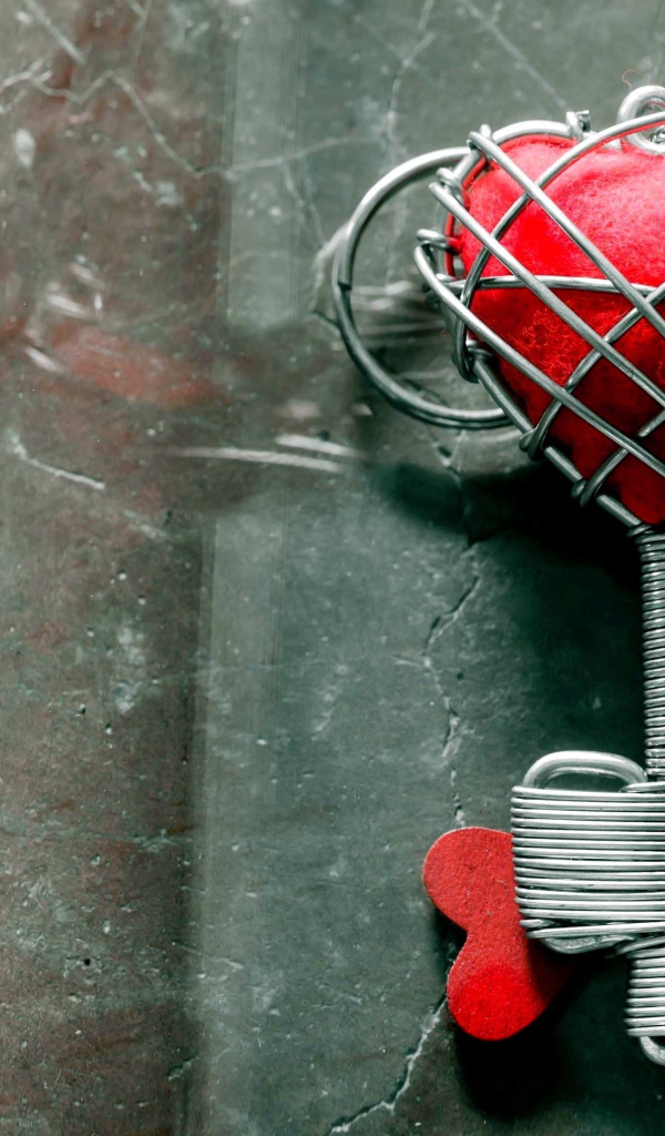 Ключ с красным сердцем на сером столе