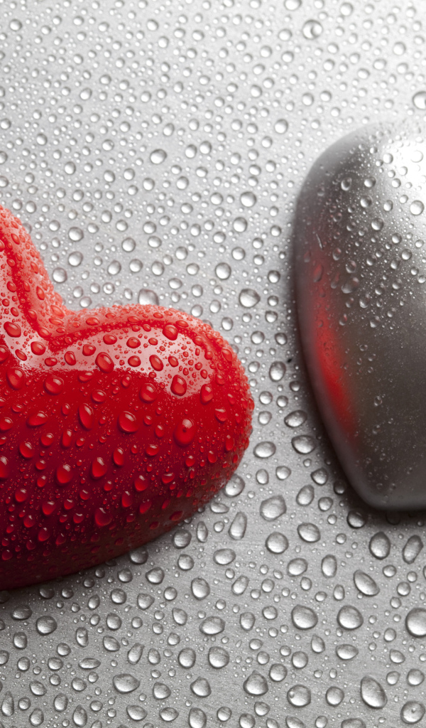 Красное и серое сердце на сером фоне в каплях воды