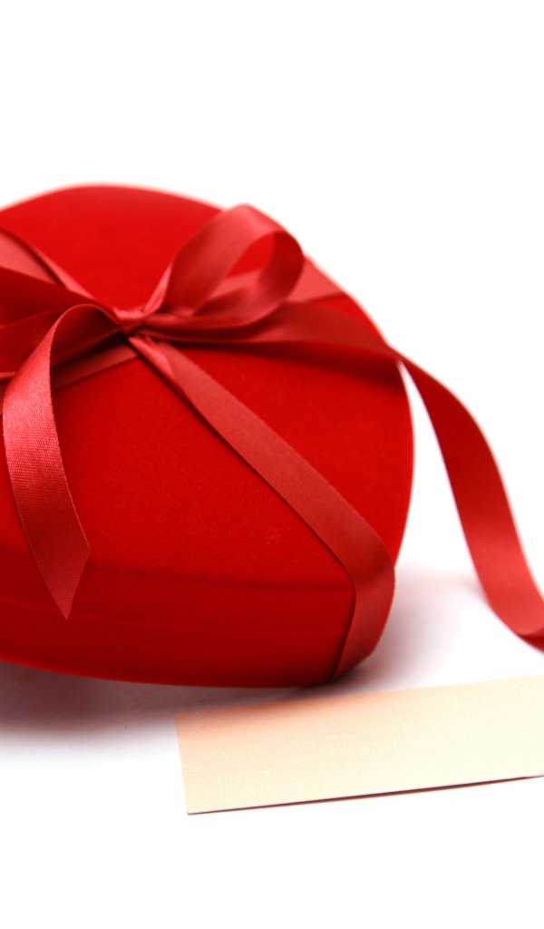 Красная коробка для ювелирных изделий в форме сердца на белом фоне 