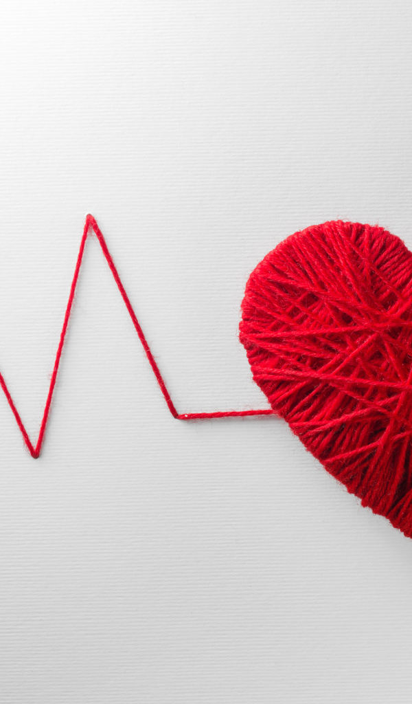 Красное сердце из нитей на сером фоне 