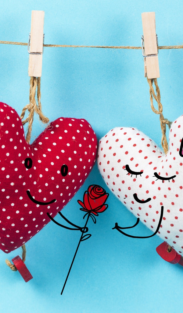 Два сердечка на прищепках на веревке на голубом фоне