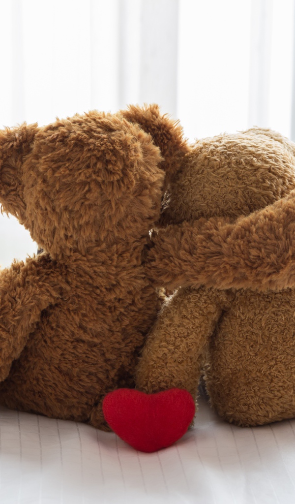 Два влюбленных плюшевых медвежонка на кровати