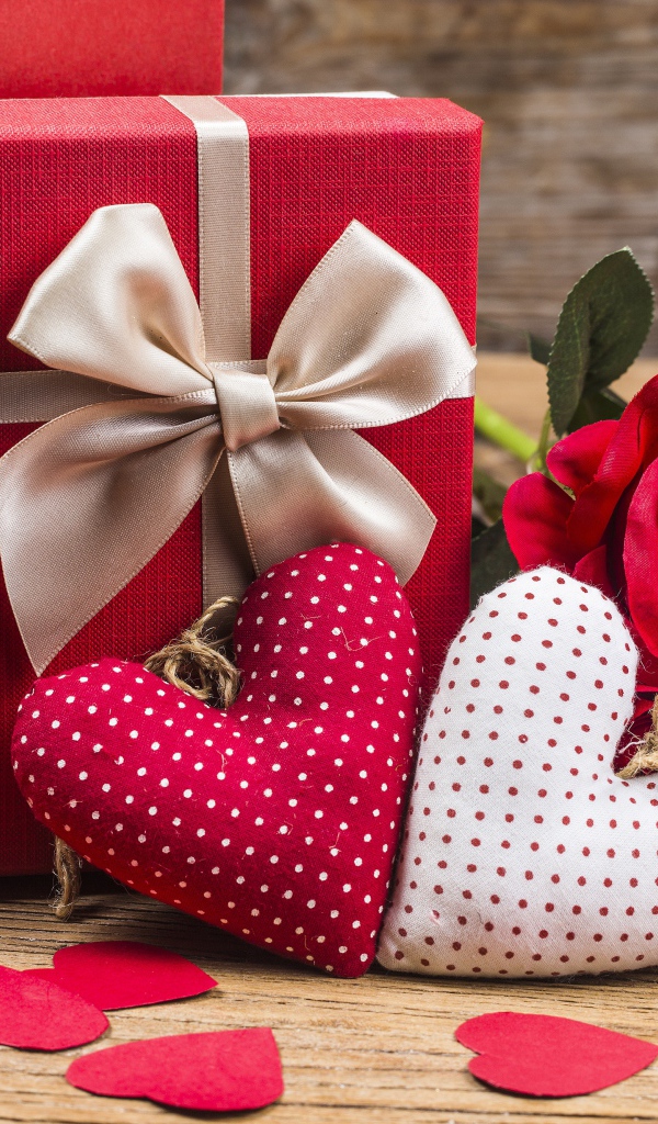 Два мягких сердечка на столе с подарком и розами для любимой