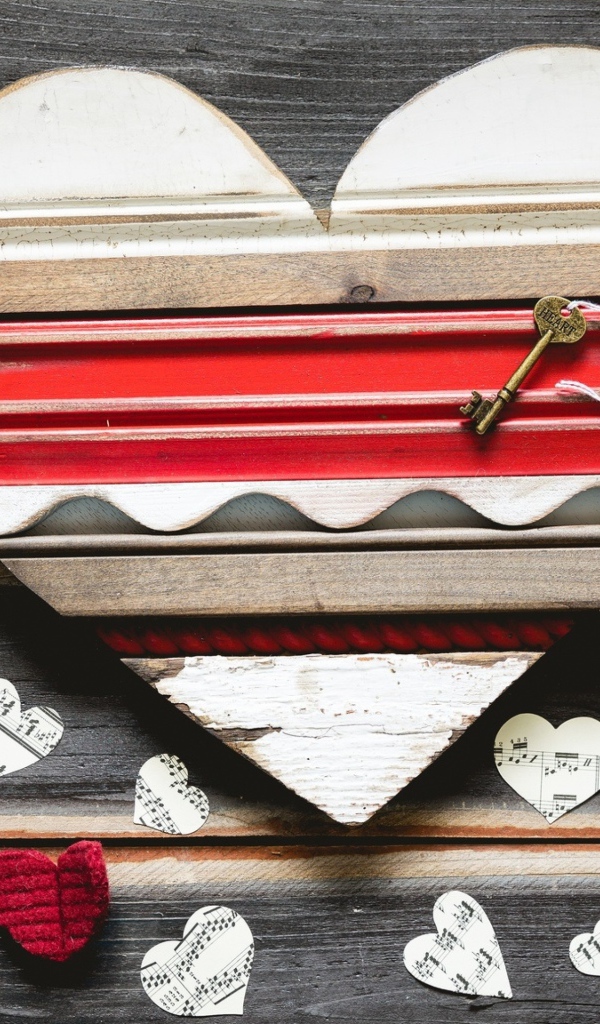 Деревянное сердце с бумажными сердечками на столе