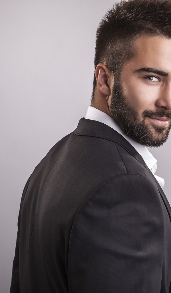 Handsome male model with a beard on gray background