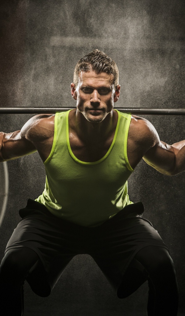 Мужчина спортсмен со штангой на плечах 