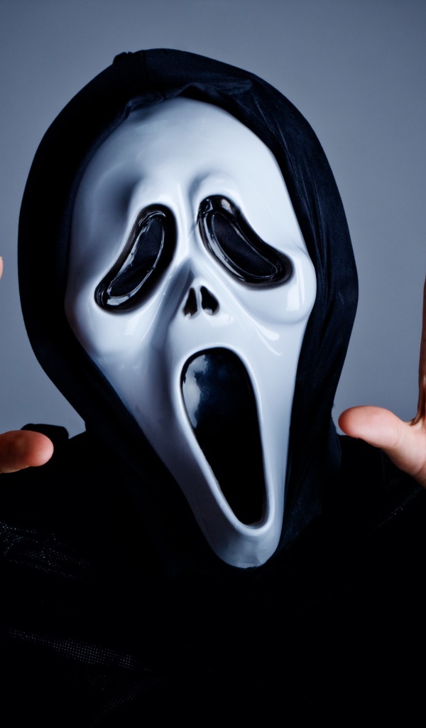 Мужчина в маске пугает на сером фоне