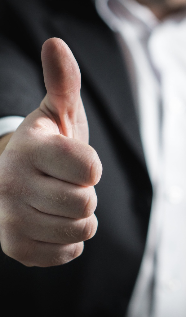 Мужчина в костюме показывает класс пальцем