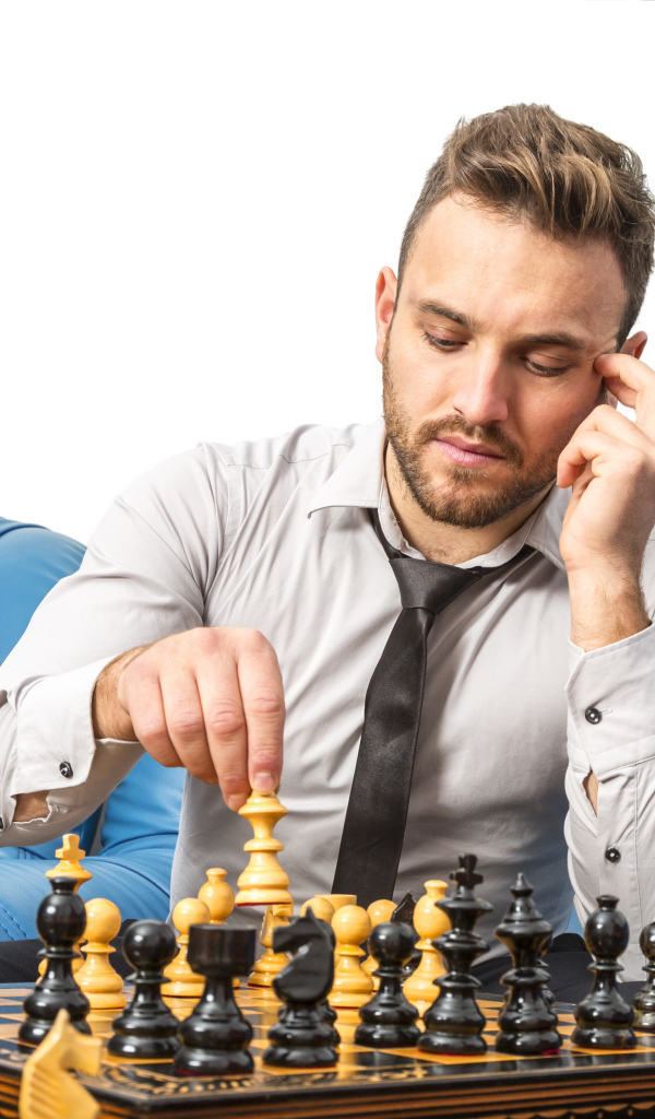 Мужчина играет в шахматы на синем диване