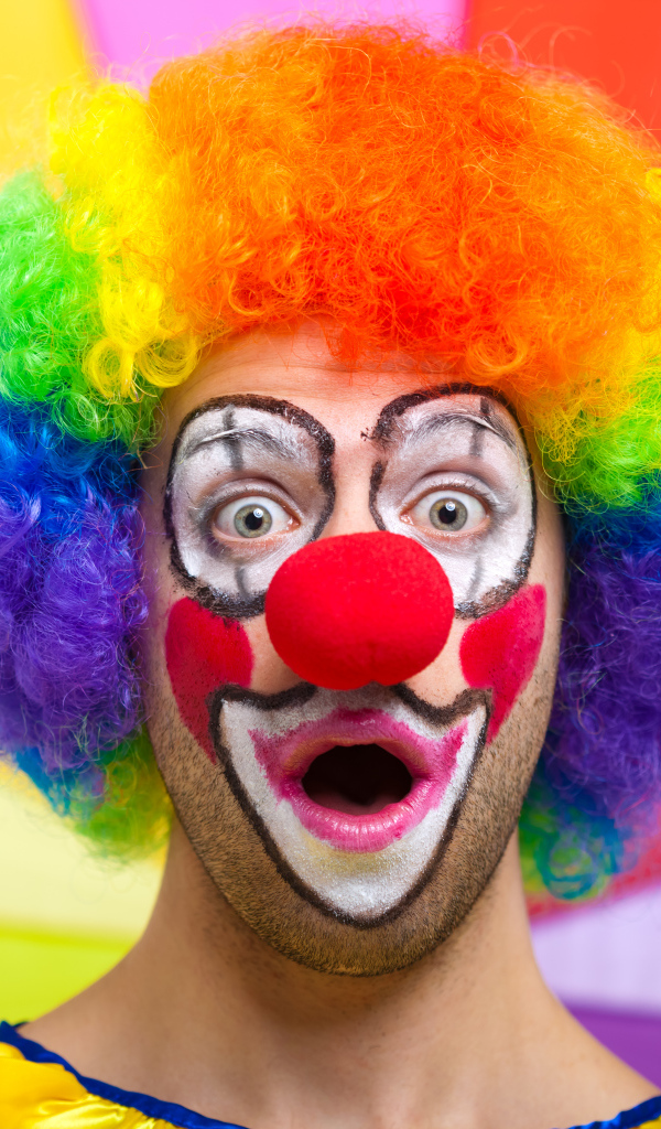 Удивленный мужчина в костюме клоуна 