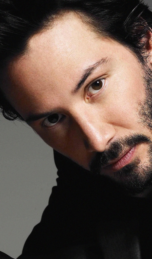 Актер Киану Ривз в костюме на сером фоне