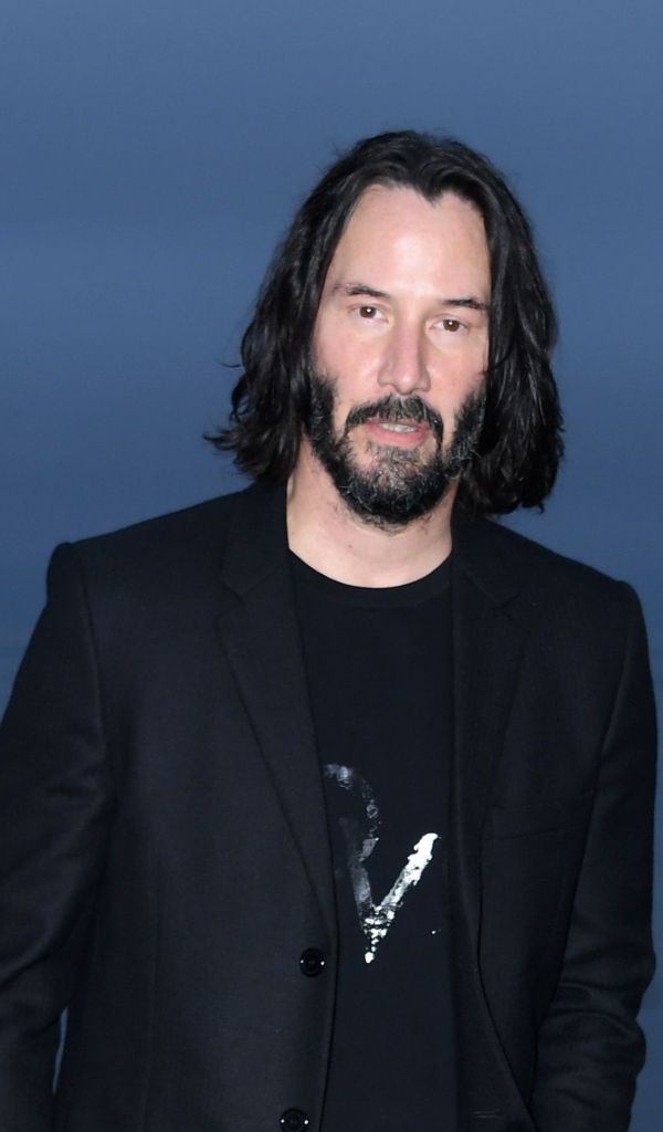 Актер Киану Ривз с бородой на синем фоне