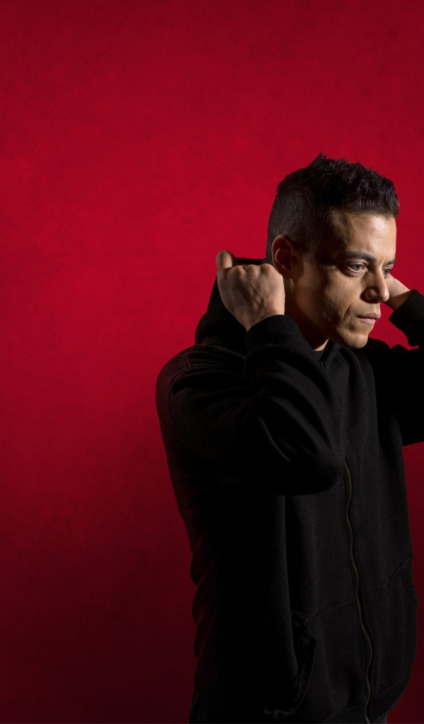 Актер Рами Малек на красном фоне