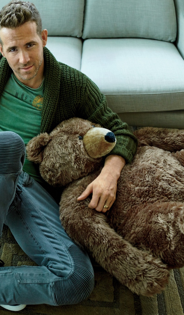 Актер Райан Рейнольдс с большим плюшевым медведем сидит на полу