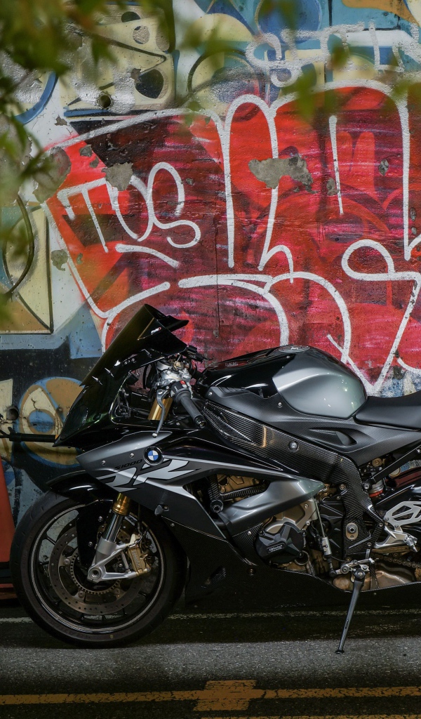 Черный мотоцикл BMW S1000RR на фоне разрисованной стены