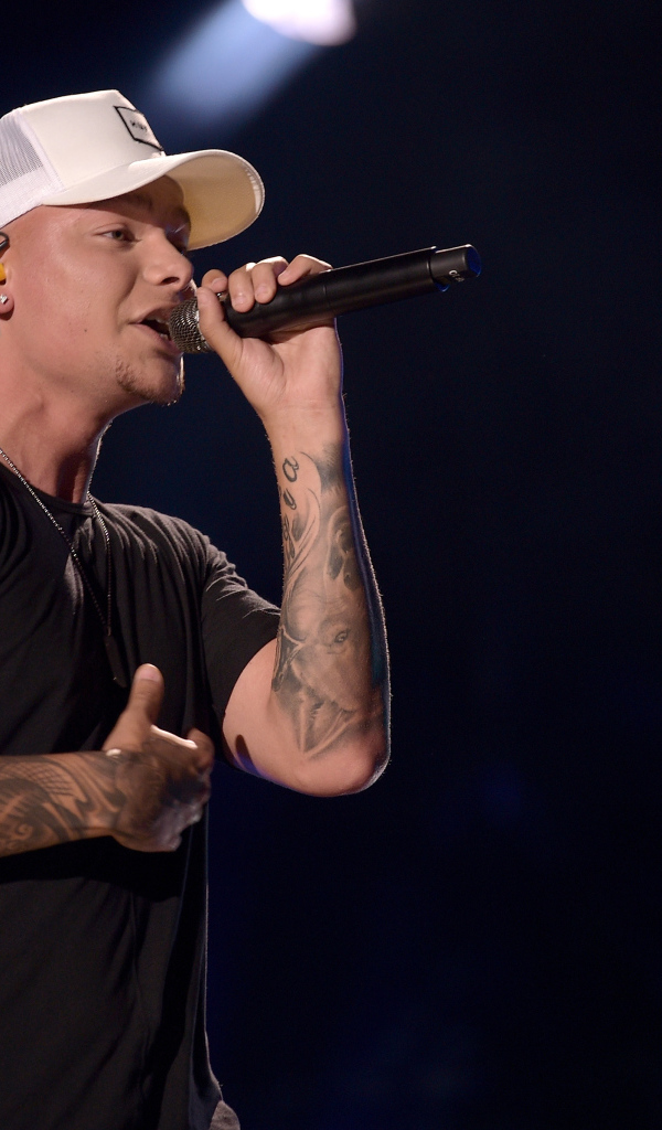 Американский кантри певец Кейн Браун с микрофоном на сцене