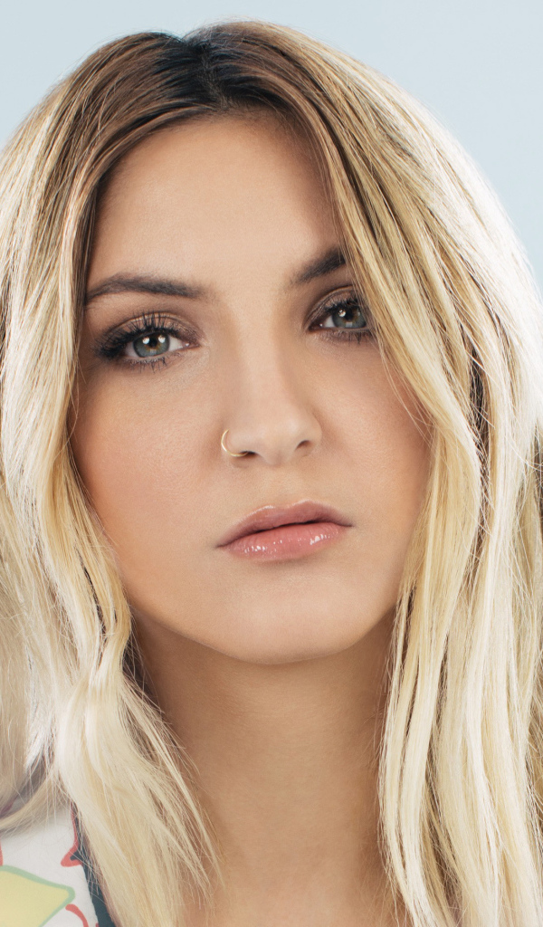 Красивая блондинка, певица Джулия Майклз на сером фоне