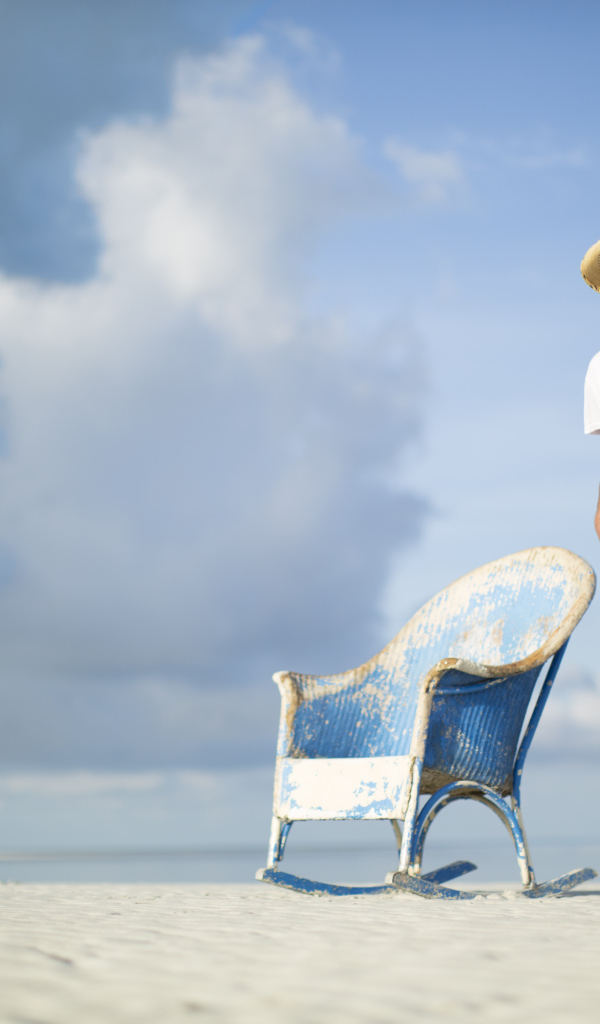 Кантри исполнитель Кенни Чесни в креслом на пляже