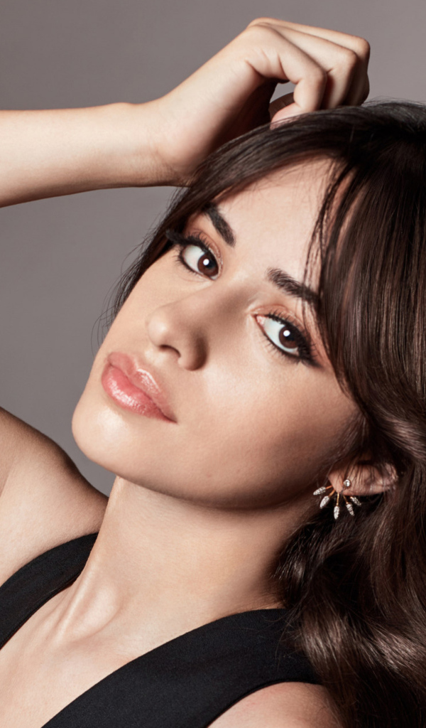 Милая кареглазая девушка, певица Камила Кабельо  на сером фоне