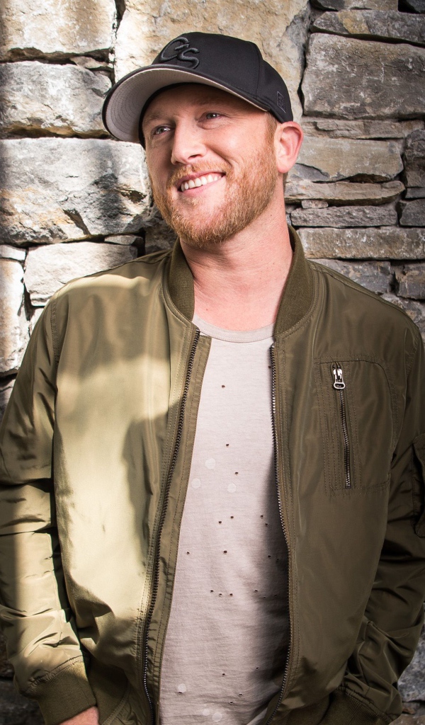 Музыкант Коул Суинделл в бейсболке у стены