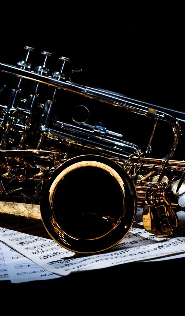 Саксофоны на нотах на черном фоне