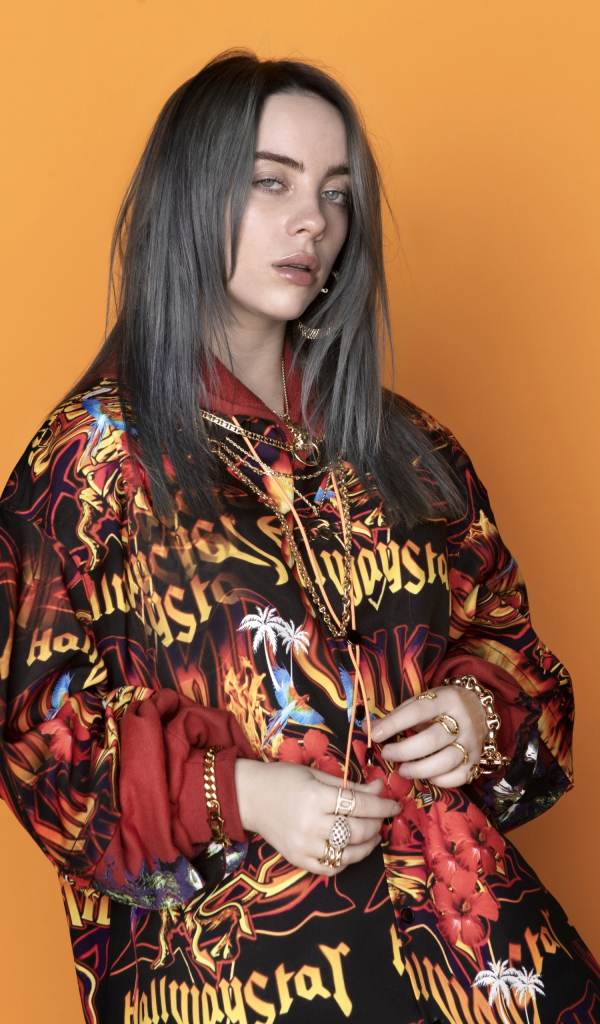 Певица Билли Айлиш на оранжевом фоне