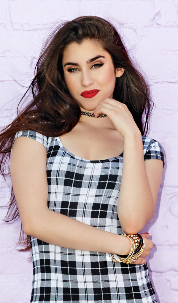 Певица Лорен Хурэги стоит у стены 