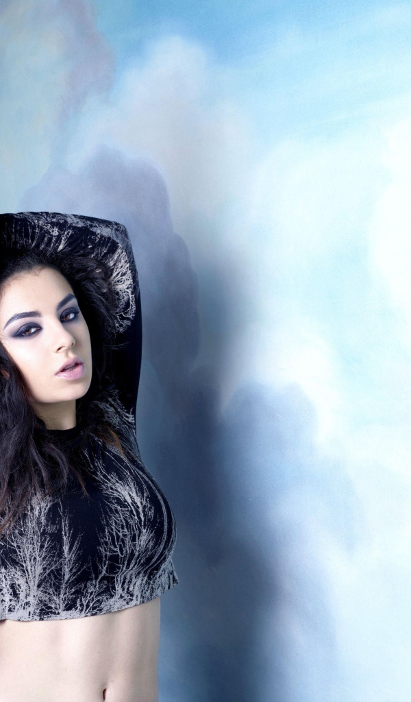 Молодая исполнительница Charli XCX  на голубом фоне