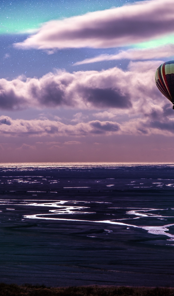 Воздушный шар в небе в белыми облаками над морем 