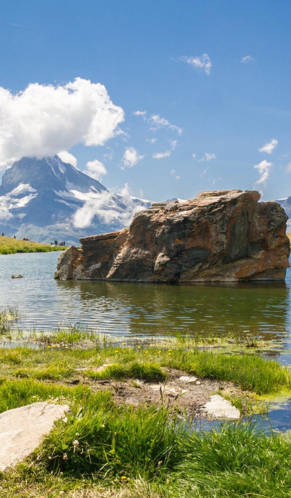 Большой камень в воде на фоне голубого неба
