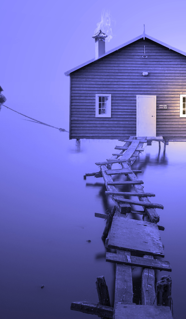 Сломанный деревянный мост к дому на воде