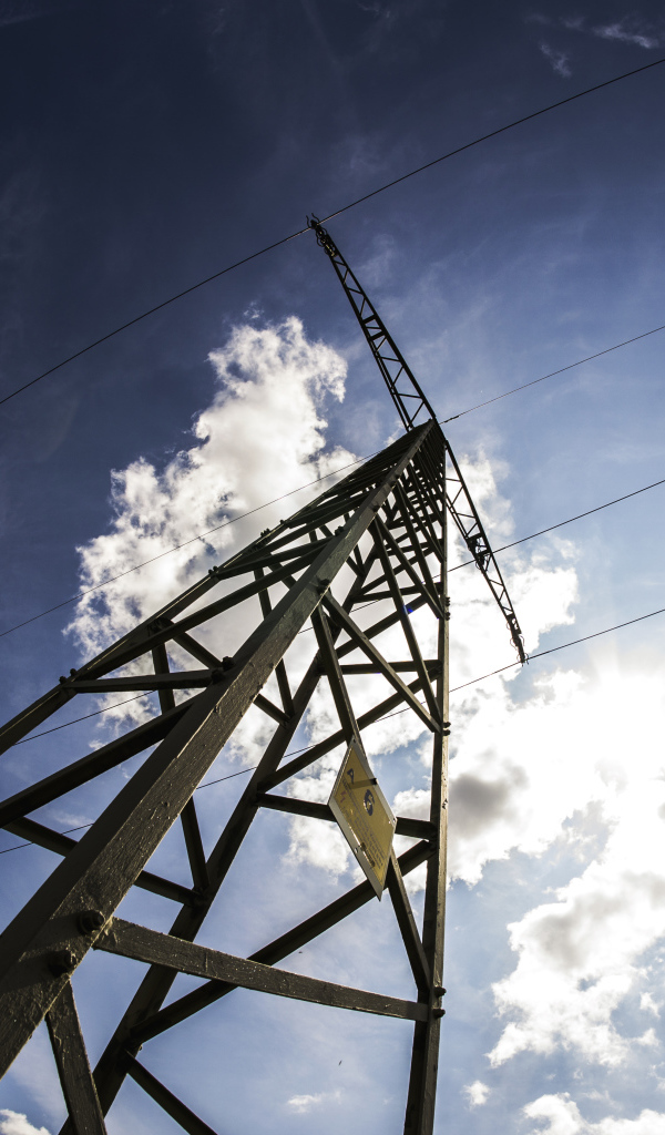 Столб линии электропередач на фоне голубого неба с облаками