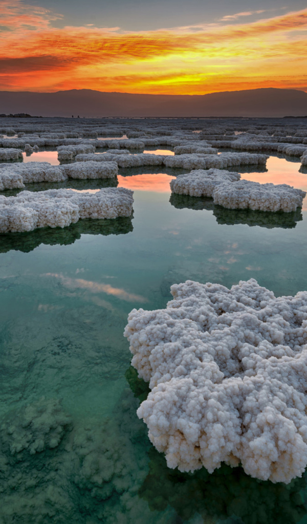 Соляные отложения в воде под красивым небом на закате