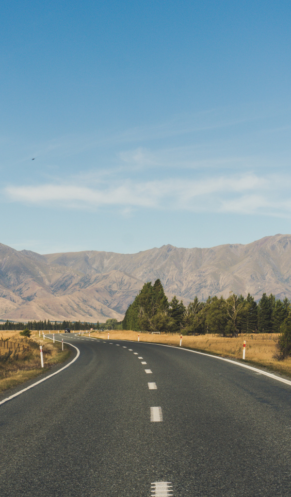 Ровная асфальтовая дорога на фоне гор 