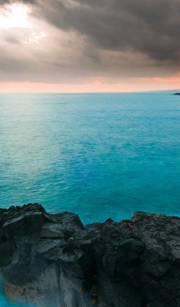 Камни в голубой воде океана под пасмурным небом