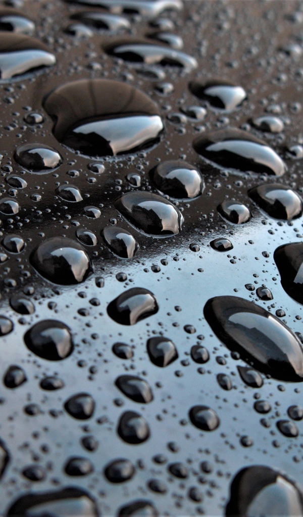 Капли воды на черной глянцевой поверхности 