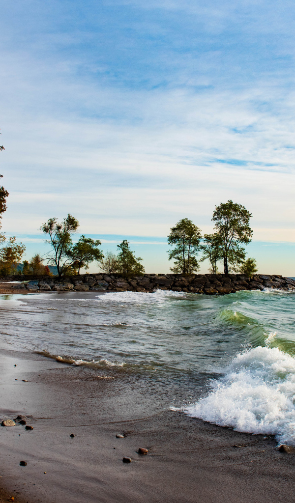Белые волны океана на мокром песке под красивым небом