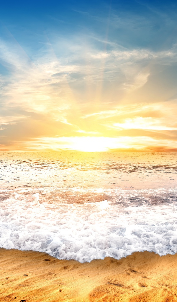 Белые волны на желтом песке на закате солнца 