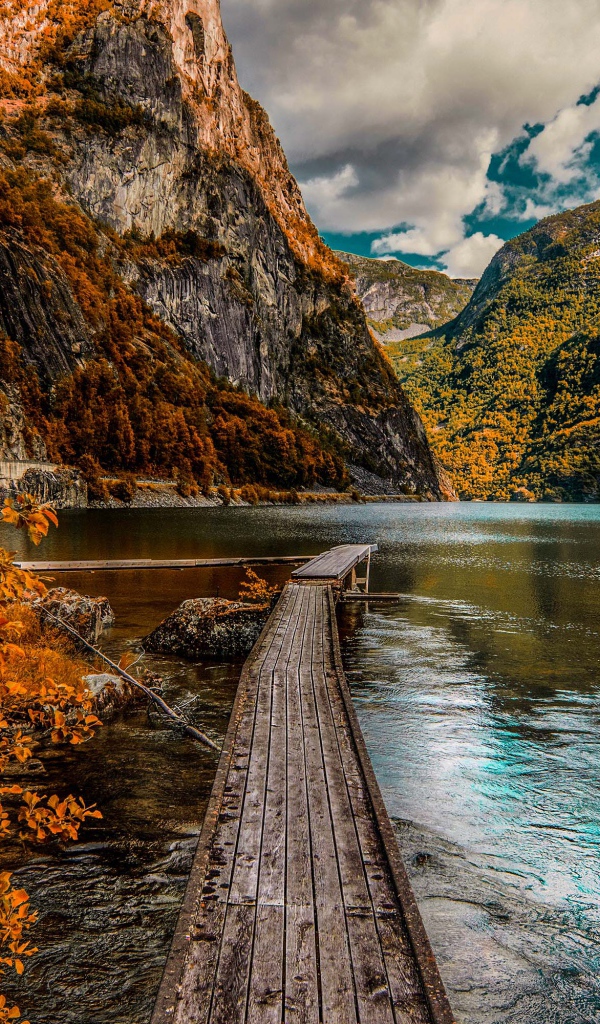 Деревянный мост в воде на фоне гор 