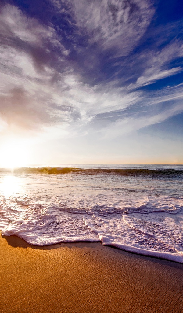 Красивые белые морские волны на теплом песке летом