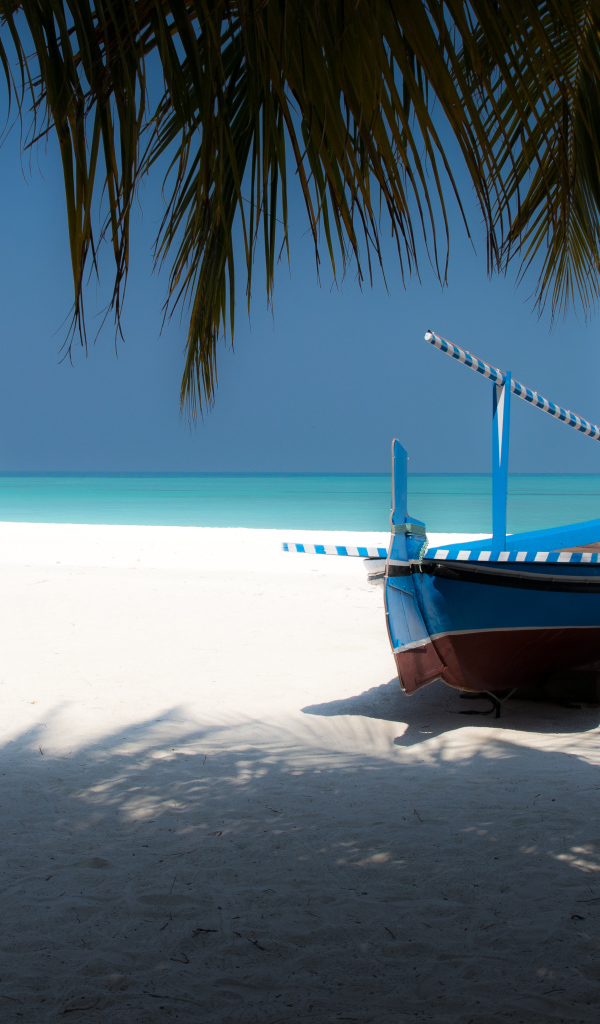 Лодка на белом песке у океана в тропиках