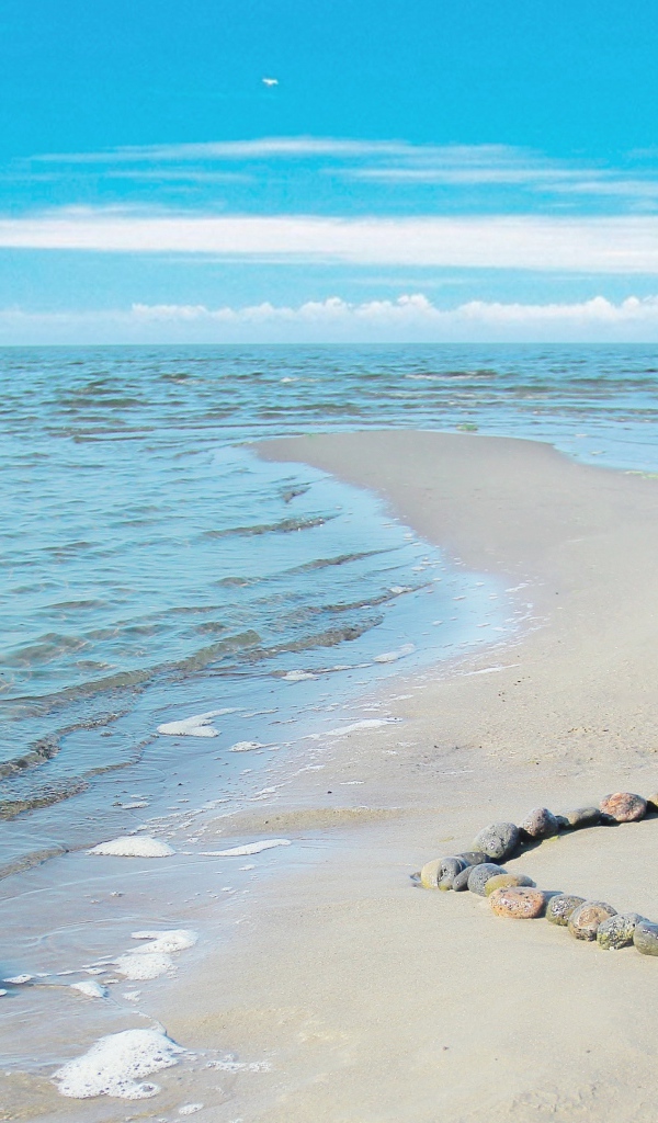 Сердце из камней на берегу теплого моря летом