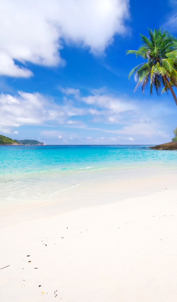 Белый песок на тропическом пляже с голубой водой 