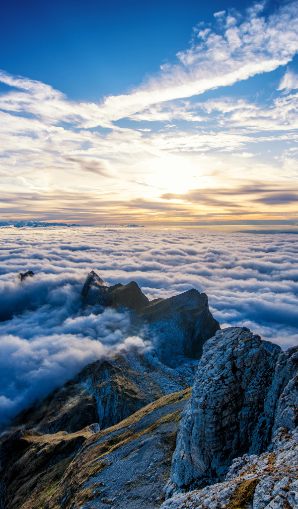 Густые белые облака над вершинами гор на рассвете