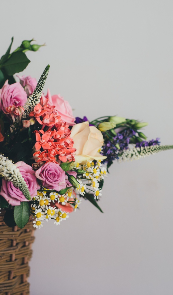 Букет цветов в корзине на сером фоне